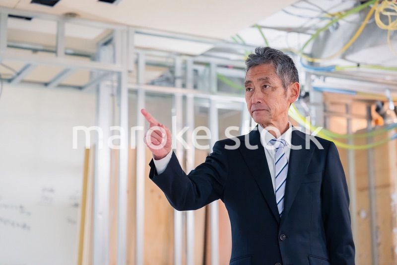 工事中の現場で指差し確認をする職人