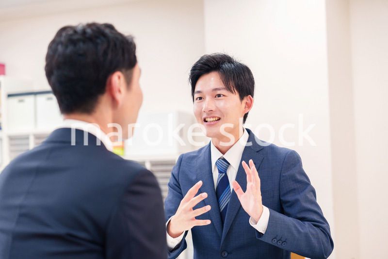 窓口で来客の対応をするビジネスマン