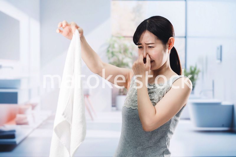 洗濯物の匂いを嗅ぐ女性