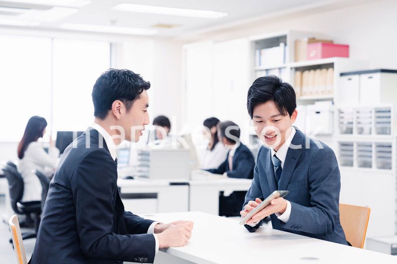 窓口でタブレットを用いて案内をする男性スタッフ