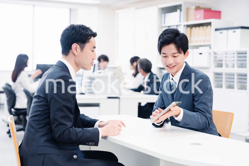 窓口でタブレットを用いて案内をする男性スタッフ