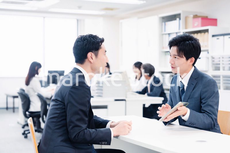 窓口でタブレットを用いて案内をする男性スタッフ