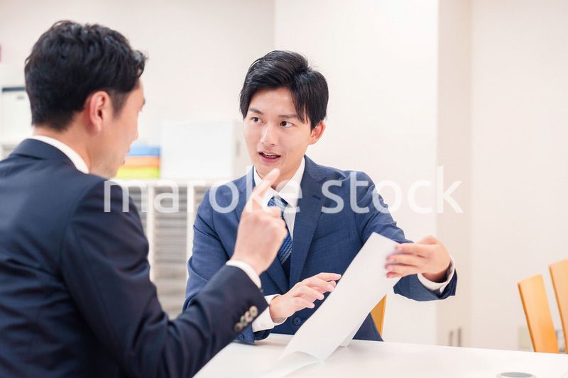 窓口で来客の対応をするビジネスマン