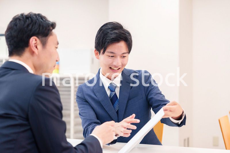 窓口で来客の対応をするビジネスマン