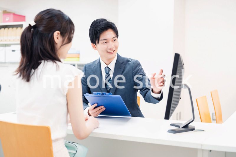 窓口で顧客の要望を聞く男性スタッフ