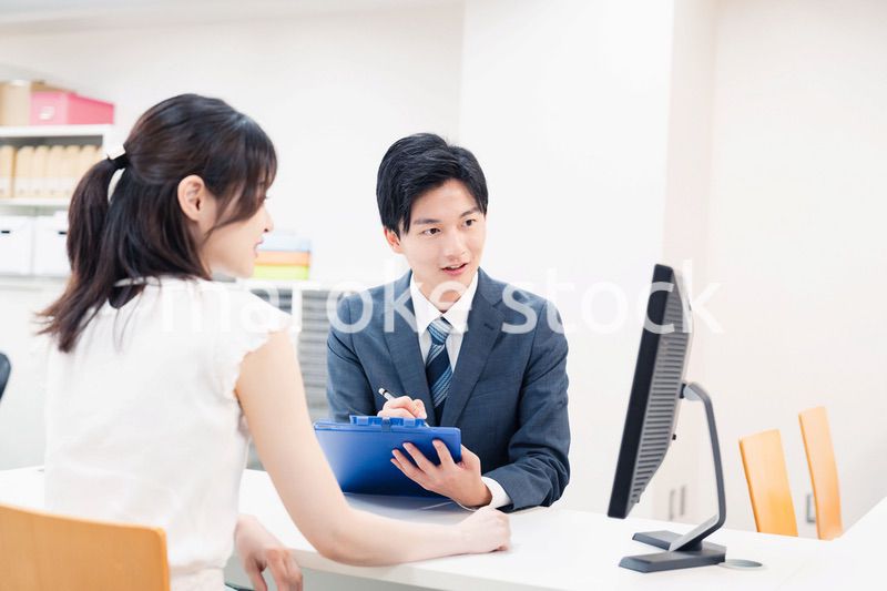 窓口で顧客の要望を聞く男性スタッフ