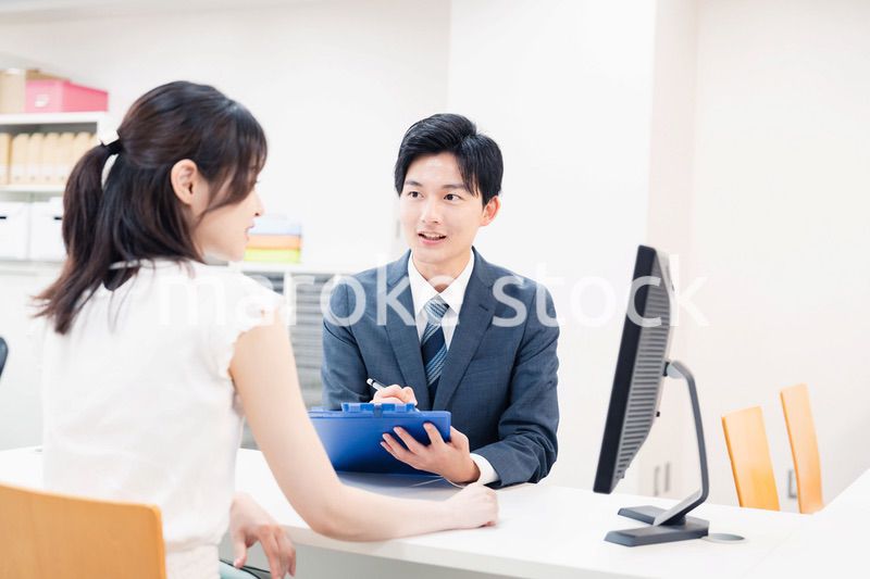 窓口で顧客の要望を聞く男性スタッフ