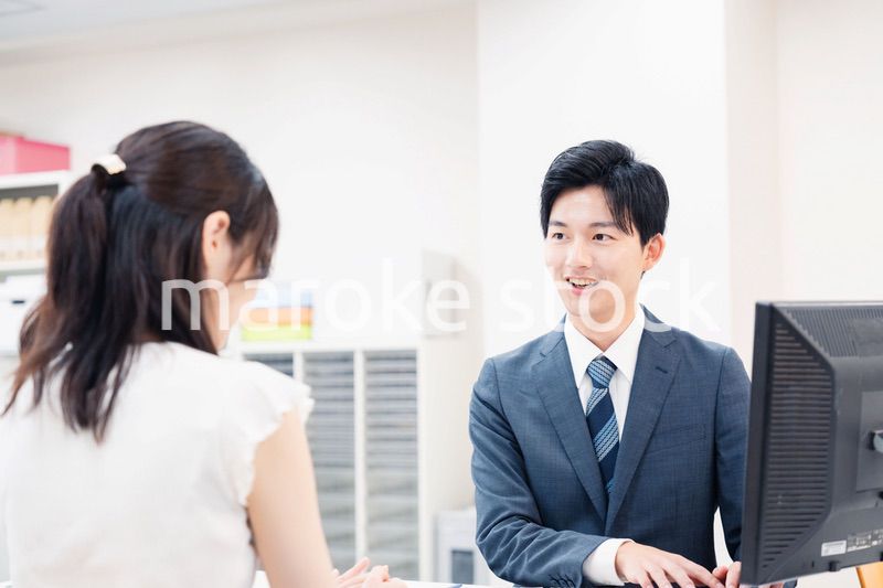 窓口で顧客の要望を聞く男性スタッフ