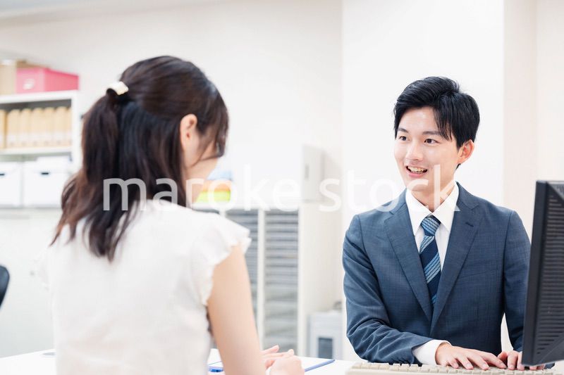 窓口で顧客の要望を聞く男性スタッフ