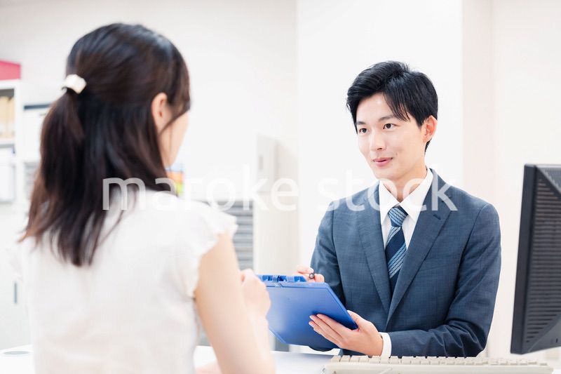 窓口で顧客の要望を聞く男性スタッフ