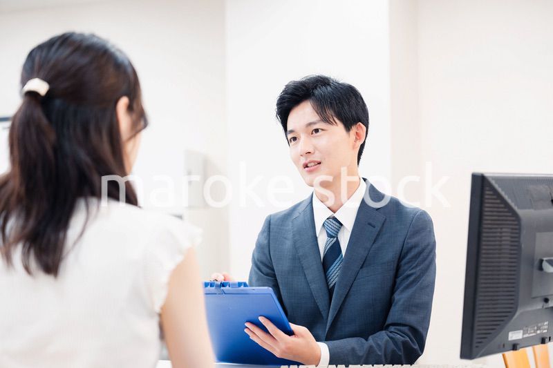 窓口で顧客の要望を聞く男性スタッフ