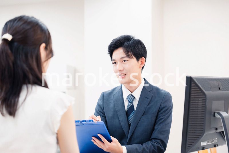 窓口で顧客の要望を聞く男性スタッフ