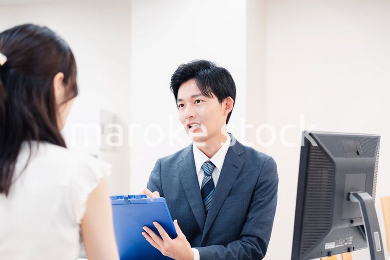 窓口で顧客の要望を聞く男性スタッフ