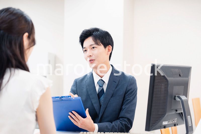 窓口で顧客の要望を聞く男性スタッフ