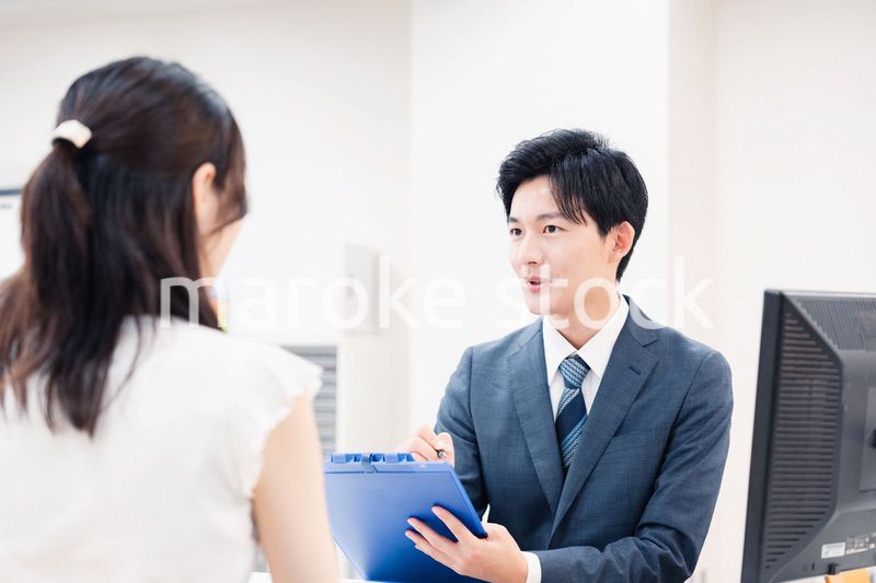 窓口で顧客の要望を聞く男性スタッフ