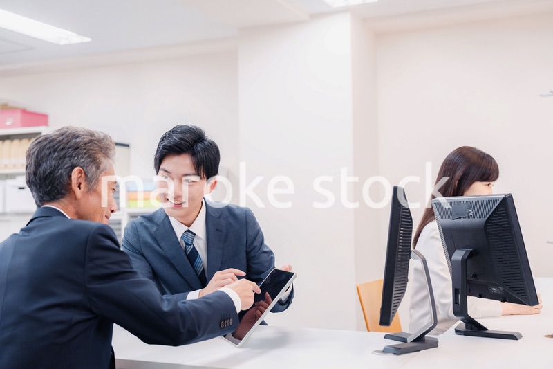 タブレットを使い窓口で接客をする男性