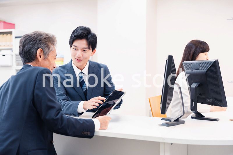 タブレットを使い窓口で接客をする男性
