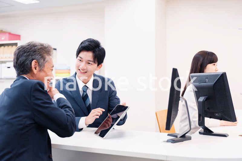 タブレットを使い窓口で接客をする男性