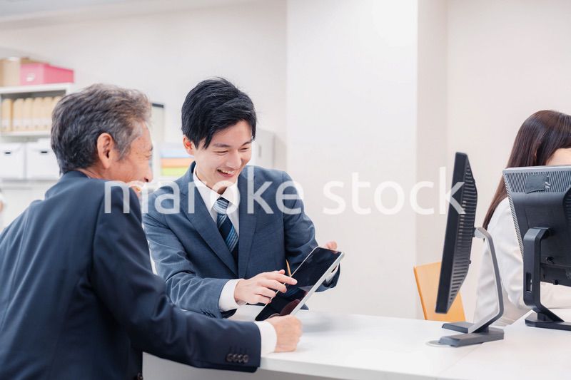 タブレットを使い窓口で接客をする男性