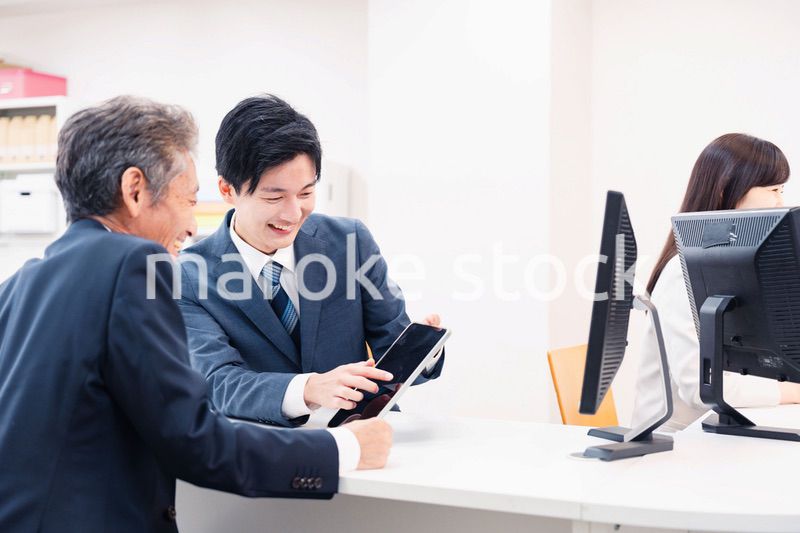 タブレットを使い窓口で接客をする男性