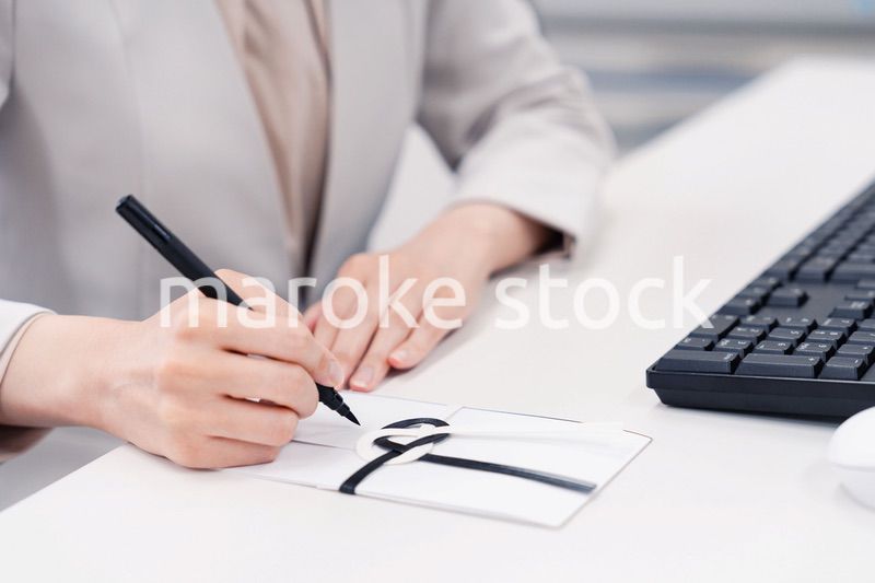 会社で葬儀の準備をする女性