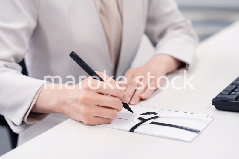 会社で葬儀の準備をする女性