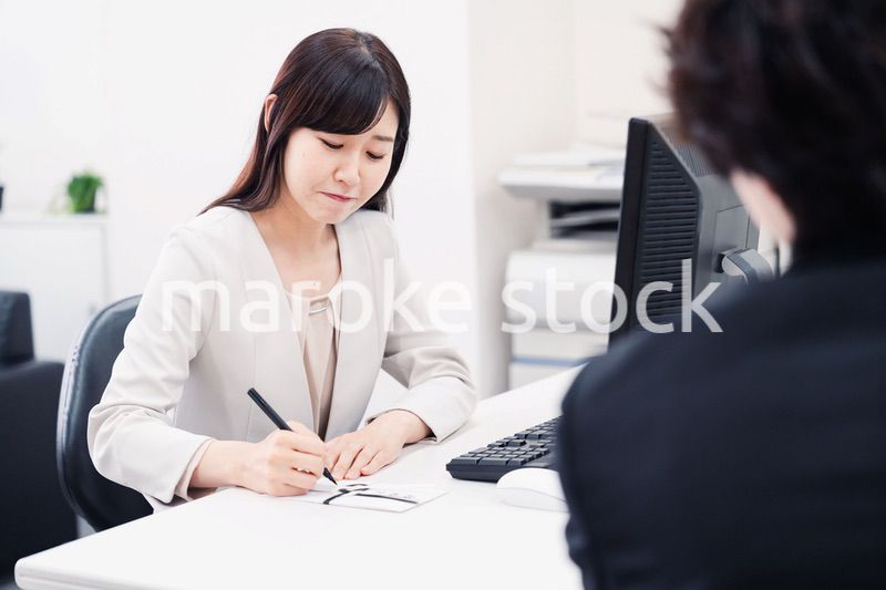 会社で葬儀の準備をする女性