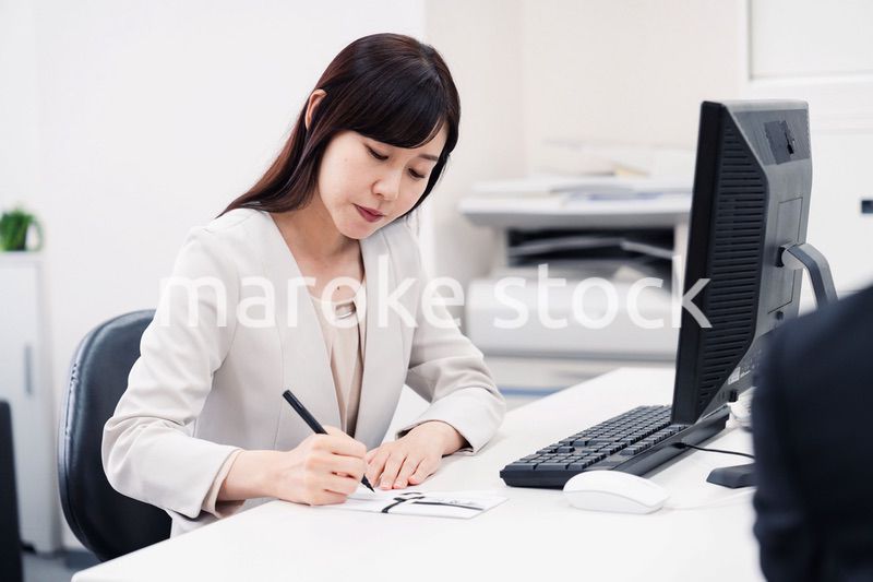 会社で葬儀の準備をする女性