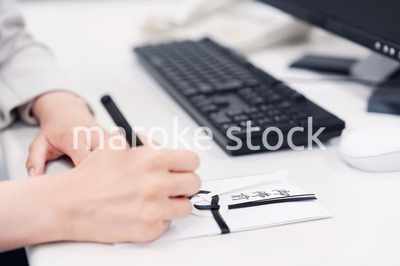 会社で葬儀の準備をする女性