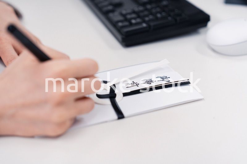 会社で葬儀の準備をする女性