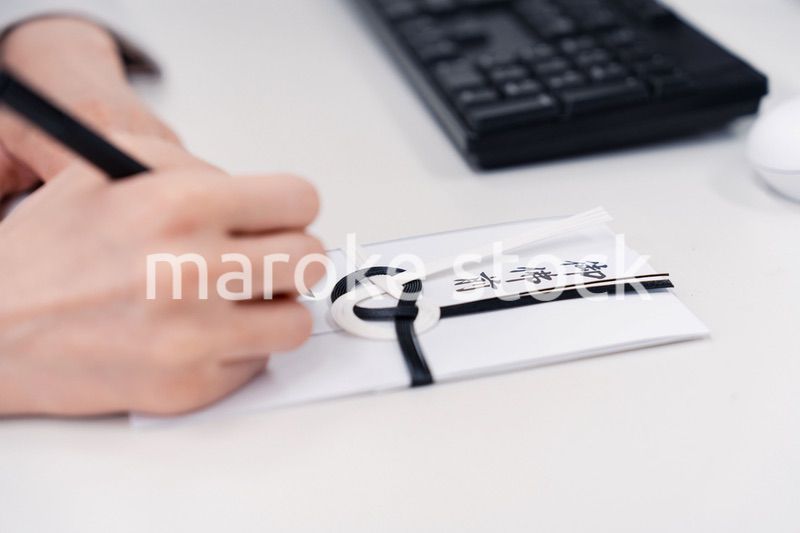 会社で葬儀の準備をする女性