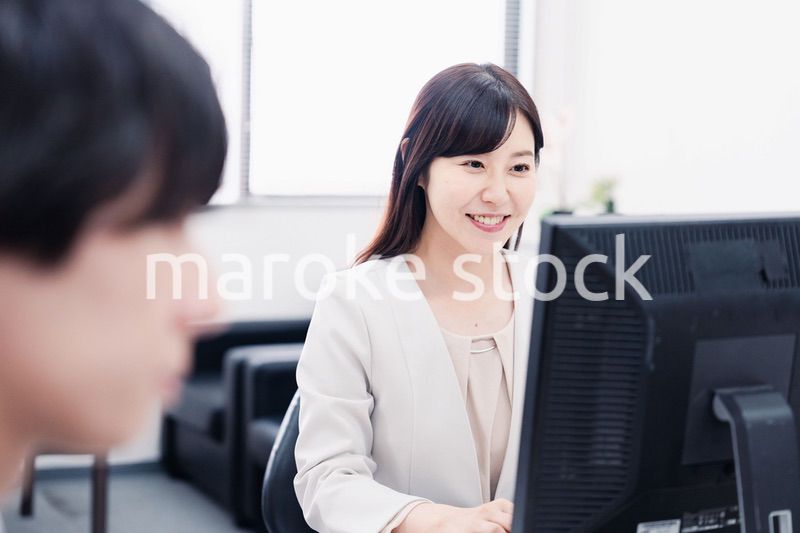 オフィスで笑顔で仕事をするオフィスワーカー