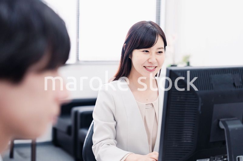 オフィスで笑顔で仕事をするオフィスワーカー