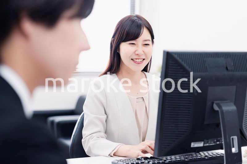 オフィスで笑顔で仕事をするオフィスワーカー