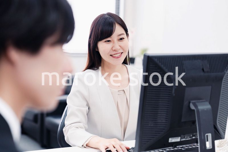 オフィスで笑顔で仕事をするオフィスワーカー