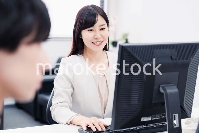 オフィスで笑顔で仕事をするオフィスワーカー