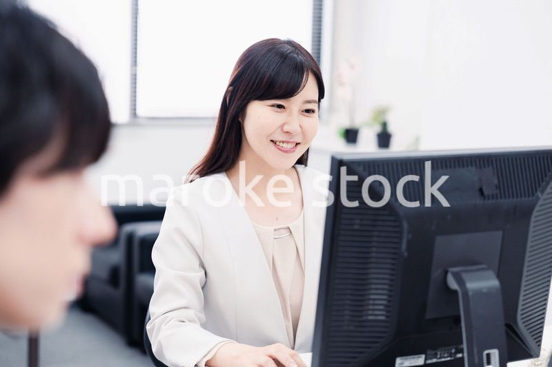 オフィスで笑顔で仕事をするオフィスワーカー