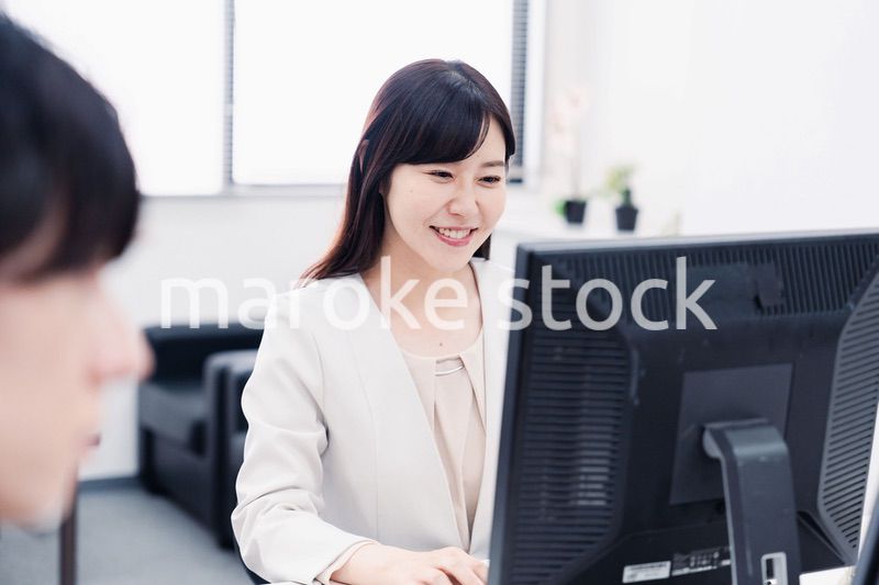 オフィスで笑顔で仕事をするオフィスワーカー