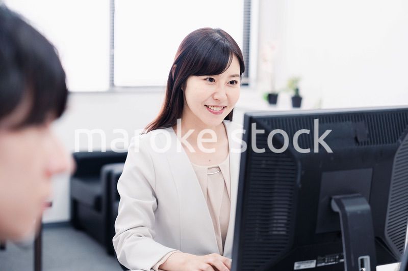 オフィスで笑顔で仕事をするオフィスワーカー