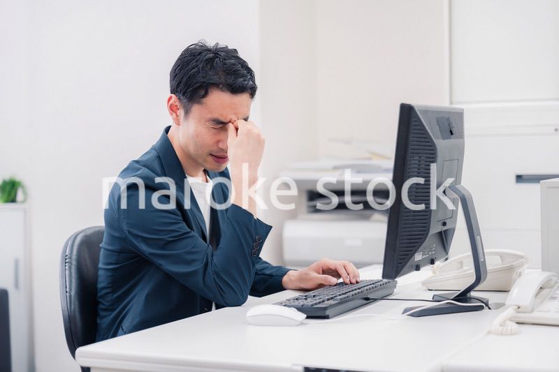 長時間労働でドライアイに苦しむビジネスマン