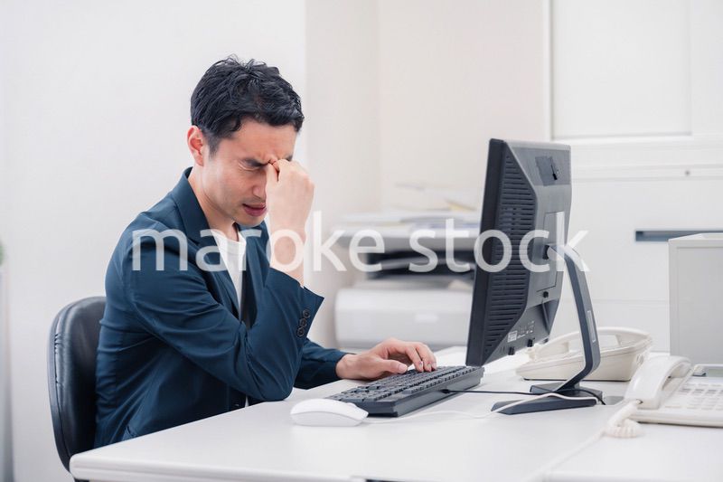 長時間労働でドライアイに苦しむビジネスマン