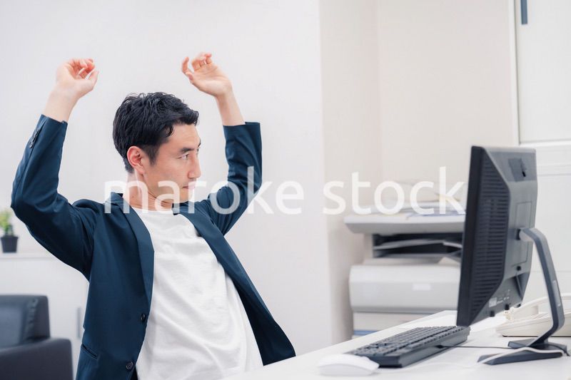 疲れて伸びをするビジネスマン