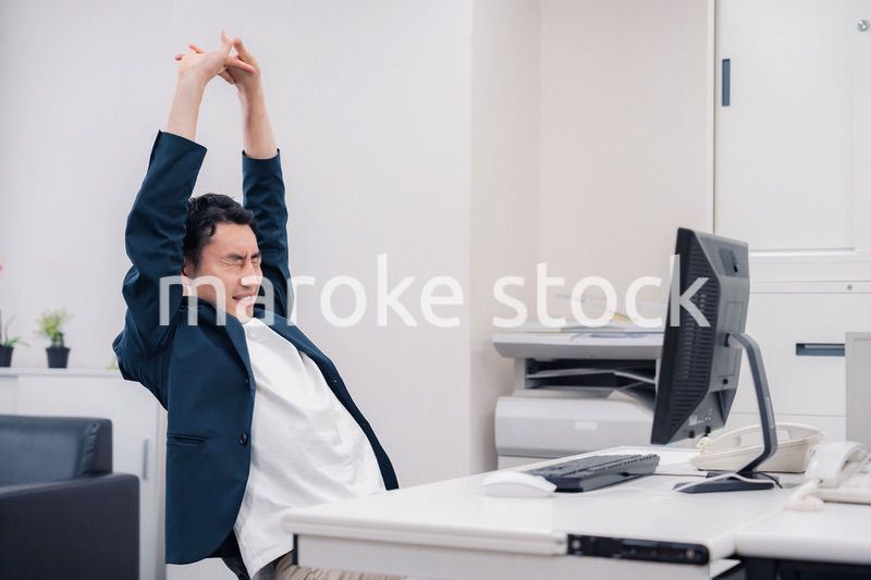 疲れて伸びをするビジネスマン