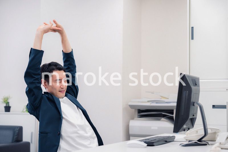 疲れて伸びをするビジネスマン