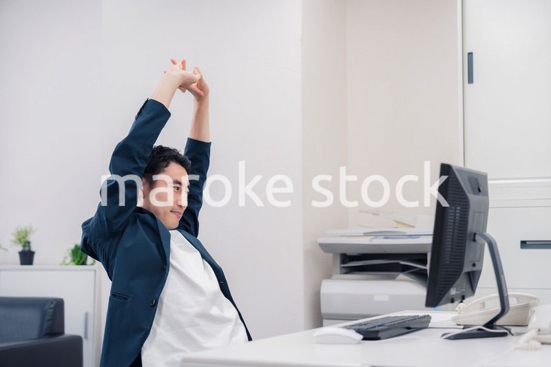 疲れて伸びをするビジネスマン