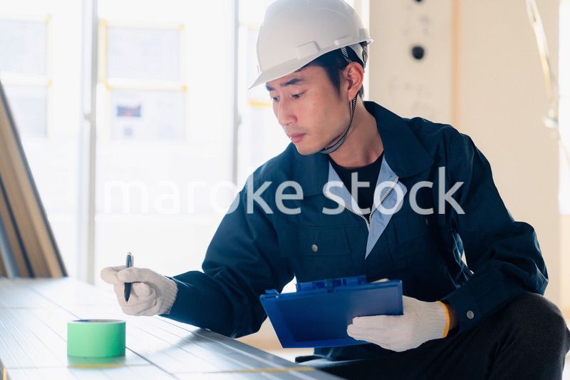 建設現場で資材の確認をする大工