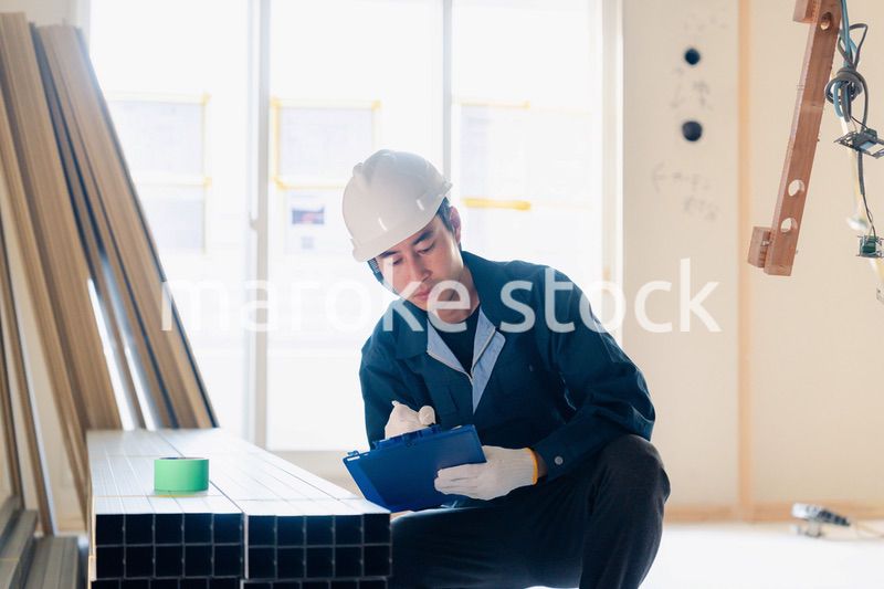 建設現場で資材の確認をする大工