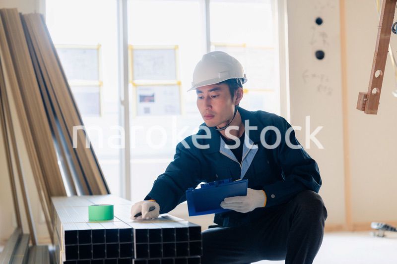 建設現場で資材の確認をする大工