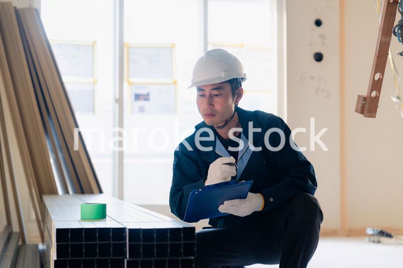 建設現場で資材の確認をする大工