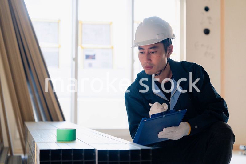 建設現場で資材の確認をする大工